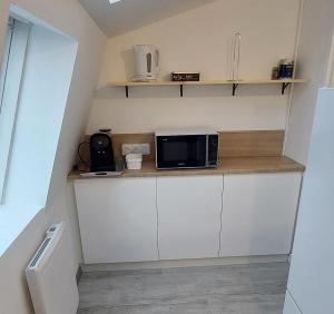 a small kitchen with a microwave on a counter at F2 - Zen & Cozy in Épinal
