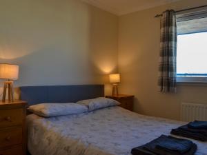 a bedroom with a large bed and a window at Ness-Side Apartment in Inverness