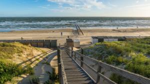 una scalinata che conduce alla spiaggia con l'oceano sullo sfondo di Centrum 26 a Brouwershaven