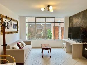 a living room with a couch and a table and a tv at Casa Cerezos in Ica