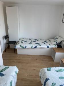 a bedroom with two beds and a chair at Motel Żabka in Łyse
