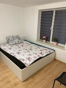 a bed in a room with two windows at Motel Żabka in Łyse