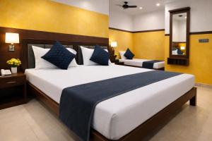 a bedroom with a large white bed with blue pillows at Hotel Hare Krishna & Banquet, Vrindavan in Vrindāvan