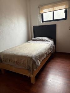a bedroom with a bed in a room with a window at La Casa de Ikal Zacatlán in Zacatlán