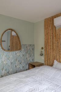 a bedroom with a bed and a mirror on the wall at אי שם בגולן in Keshet