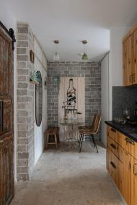 a kitchen with a brick wall and a table and chairs at אי שם בגולן in Keshet