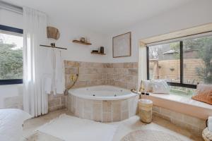 a large bathroom with a tub and a window at אי שם בגולן in Keshet +17 photos