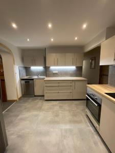 a large kitchen with white cabinets and appliances at Le Chalet in Les Deux Alpes