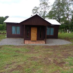 a small wooden house with a large yard at Cabañas Gasparín Sur in Río Bueno