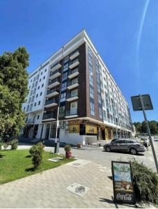 a large building with a car parked in front of it at Zeus Apartman in Jagodina