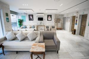 a living room with a large white couch and chairs at فندق اسكان وافر in An Naqāʼ