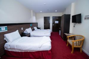 a hotel room with two beds and a television at فندق اسكان وافر in An Naqāʼ +45 photos