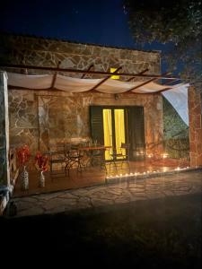 a stone house with a patio at night at oleabungalows in Akrotiri