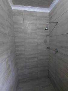 a bathroom with a shower with a glass door at Mama R's Budget-friendly BACKROOM 3 in Newcastle +17 photos