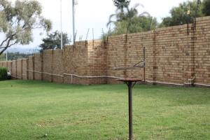 a pole in the grass in front of a brick wall at Stonewall Luxury Apartment in Northriding