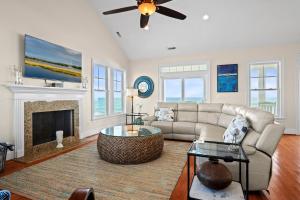 a living room with a couch and a fireplace at Aqua Vista by Emerald Isle Realty in Emerald Isle