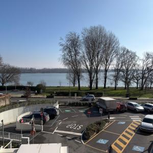 a parking lot with cars parked next to a lake at Residenza Bibiena - Lake View - in Mantova