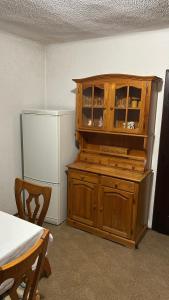 a kitchen with a wooden cabinet next to a refrigerator at Apartments Vila Ančka in Tržič