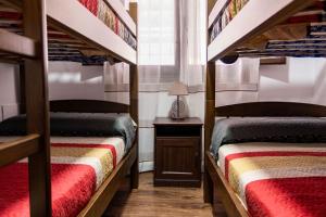 two bunk beds in a room with a table and a lamp at casa rural Cerro laute in Lanjarón