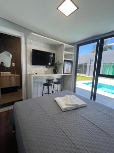 a bedroom with a bed with a tv on the wall at Pousada Selenita in Ametista do Sul