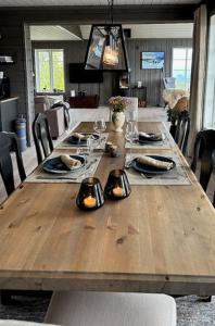 a wooden table with plates and lights on it at Cabin With Panoramic Views Over The Mountains in Nesbyen +32 photos