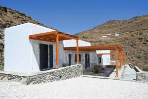 a white house with a wooden pergola at Alkyoni Celeste Kythnos in Kithnos