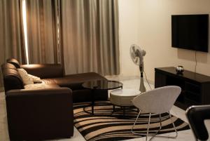 a living room with a leather couch and a table at Muka Staytel in Ndola