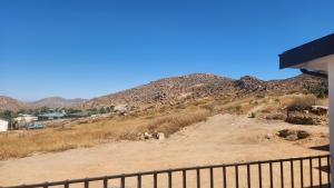 a hill with some animals on a dirt road at Sand Fontein in Springbok +1 photo