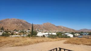 a dirt road leading to a small town with mountains at Sand Fontein in Springbok