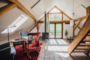 a living room with wooden beams and a table and chairs at Gospodarstwo ekoturystyczne ARTYSTYKA in Bystrzyca Kłodzka