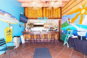 a restaurant with a bar with stools in a room at Beach Studio with Partial Water Views Sundeck Pool in Daytona Beach