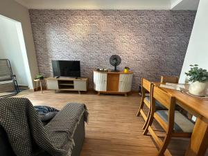 a living room with a television and a table at Apê do Viajante in Vila Velha