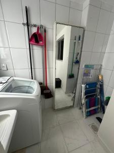 a bathroom with a washing machine and a mirror at Apê do Viajante in Vila Velha +19 photos