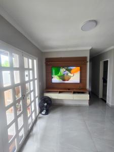 a living room with a flat screen tv on a wall at Casa dos Carvalhos in Piranhas