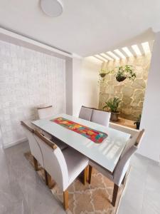 a dining room with a white table and chairs at Casa dos Carvalhos in Piranhas