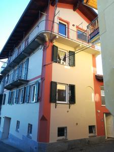 ein orange-weißes Gebäude mit einem Balkon in der Unterkunft Buonacqua in Tavigliano