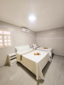 a bedroom with two beds and a window at Casa dos Carvalhos in Piranhas