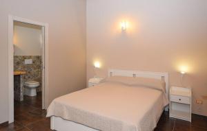 a bedroom with a bed and a toilet and two lights on the wall at A Valata di Donnafugata in Ragusa +22 photos