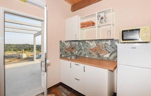 a kitchen with a white refrigerator and a window at A Valata di Donnafugata in Ragusa