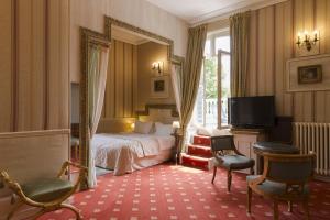 a hotel room with a bed and a mirror at Belle Isle Sur Risle - Chateau Hotel & Spa in Pont-Audemer