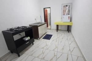 a kitchen with a stove and a sink and a tiled floor at Casa Vigia 2 Quartos in Vigia +11 photos
