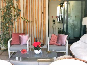 a porch with two chairs and a table with flowers at WhiteHome in Conegliano