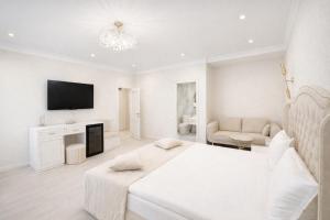 a white bedroom with a bed and a tv at Yerevan In Boutique Hotel in Yerevan