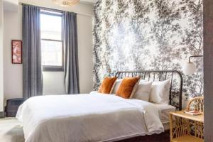 a bedroom with a white bed with a floral wallpaper at Inn at Gough in San Francisco +11 photos