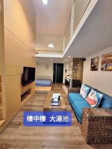 a living room with a blue couch and a tv at Capybara樓中樓湯屋 in Jiaoxi +16 photos