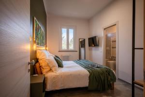 a bedroom with a bed and a bathroom at La Corte Rooms Pisa in Pisa