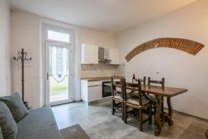 a kitchen and dining room with a table and chairs at La Corte Rooms Pisa in Pisa