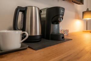 a coffee maker sitting on a table next to a cup at La Corte Rooms Pisa in Pisa