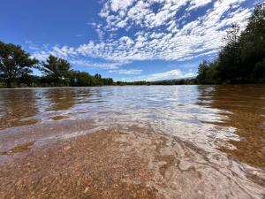 a view of a body of water with trees and clouds at Duplex Playa Mansa in Mina Clavero