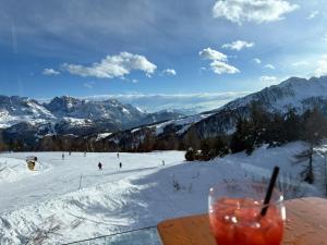 a drink sitting on a table with a ski slope at Monalisa sweet house - Appartamento Marilleva 1400 in Marilleva